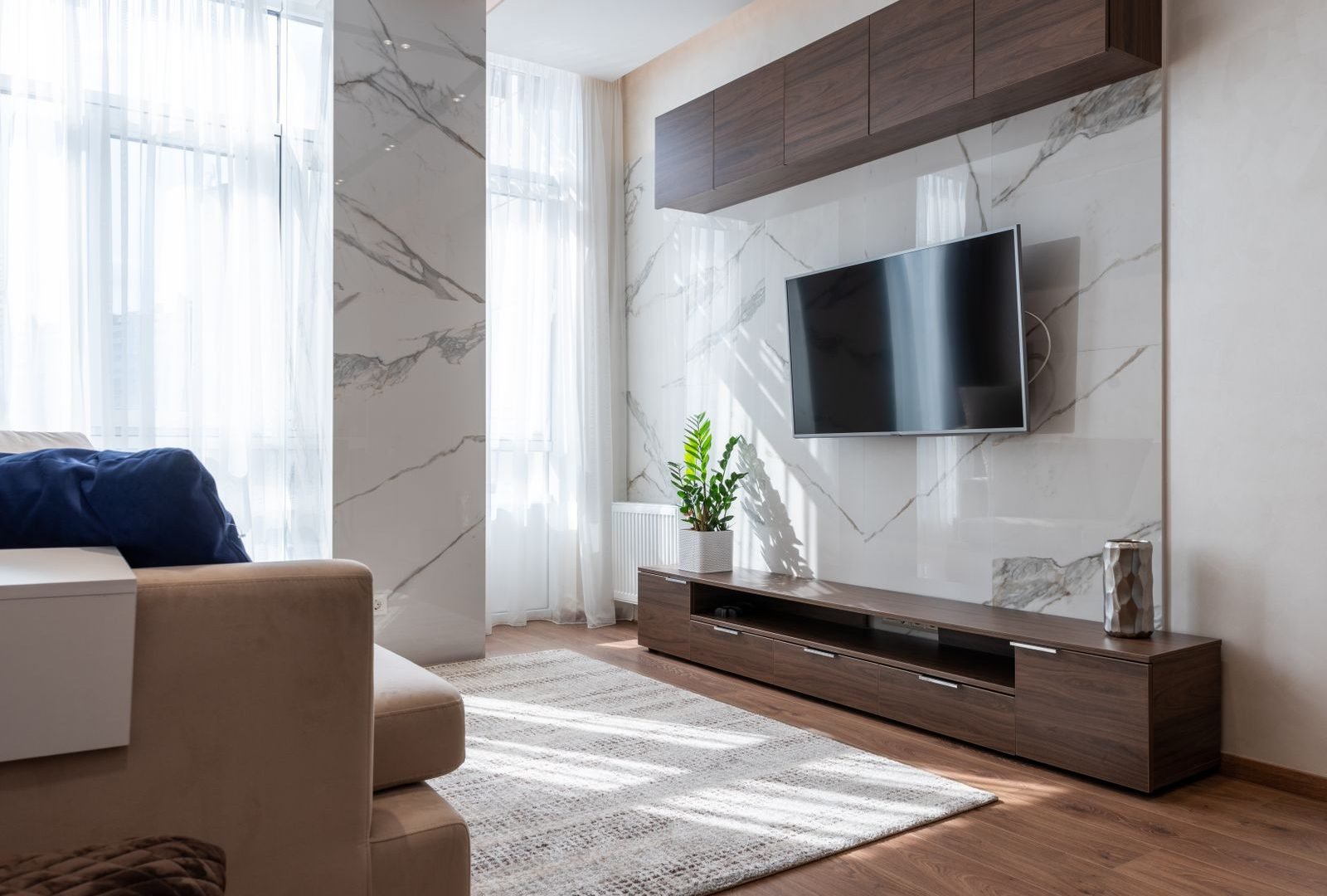 Modern living room interior fit-out with marble accent wall and wood cabinetry