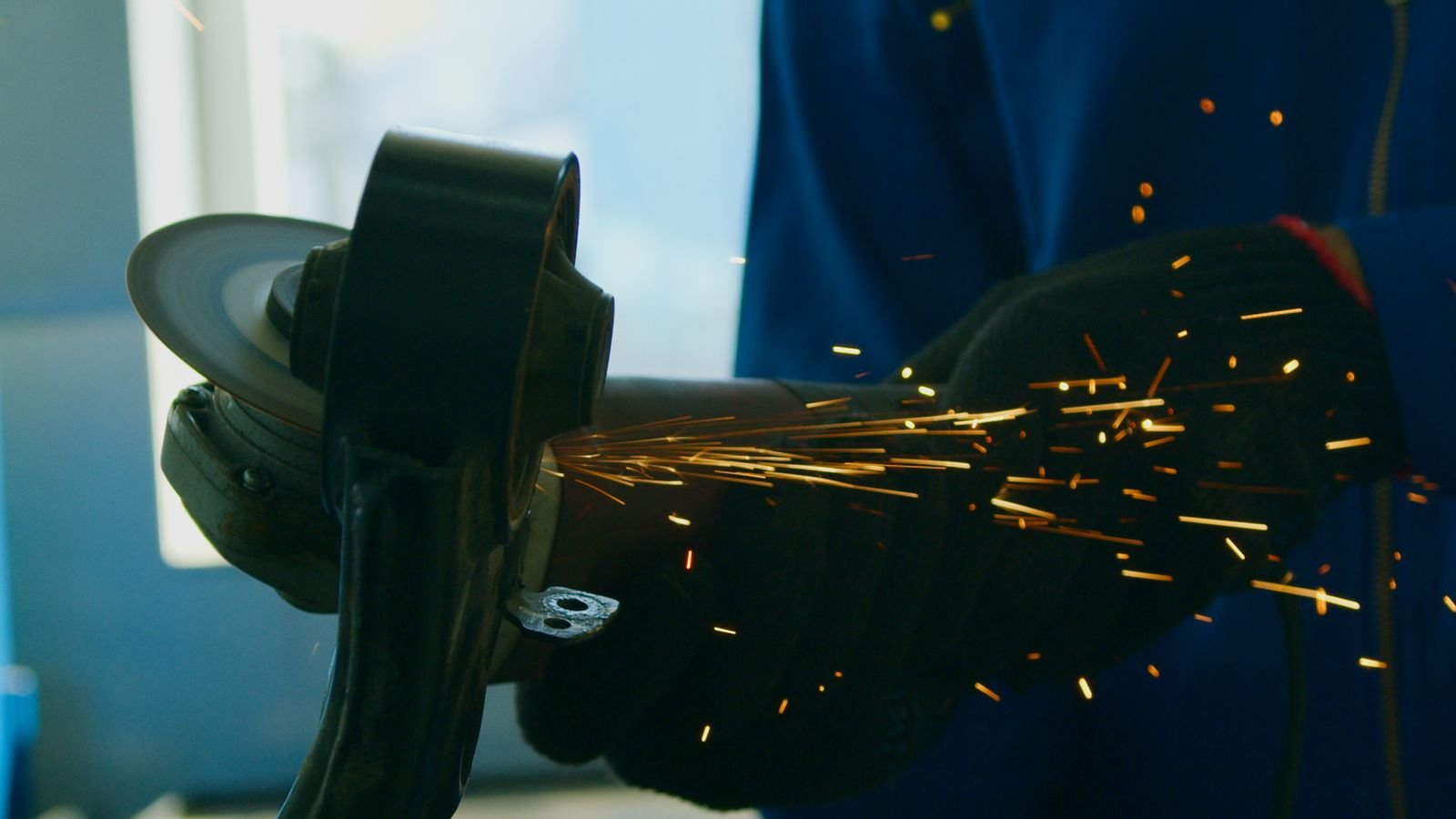 Craftsman using a grinder in a stone fabrication workshop